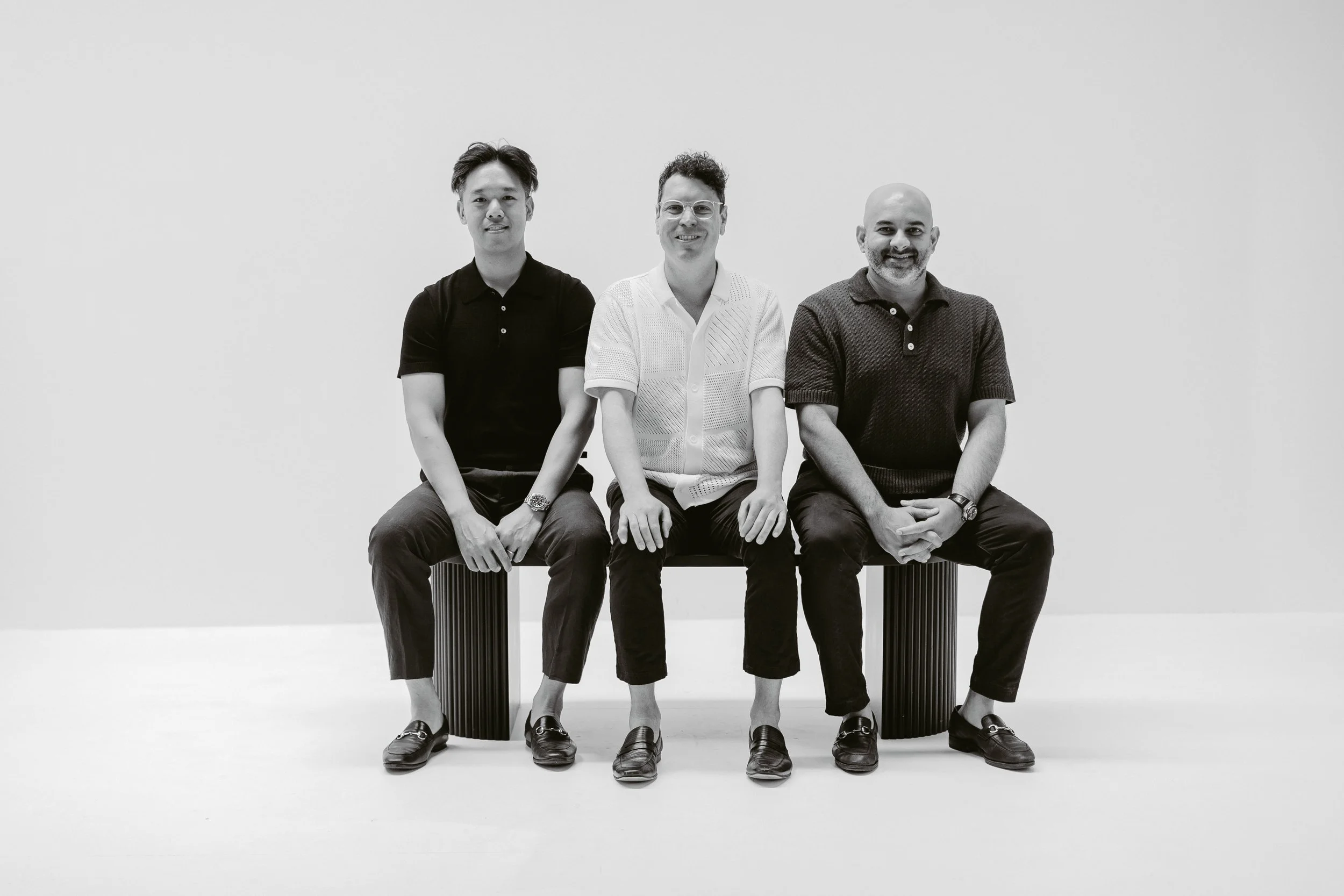 The three YLG Capital founders seated in a pale studio